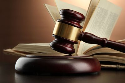15456279 - wooden gavel and book on wooden table, on brown background
