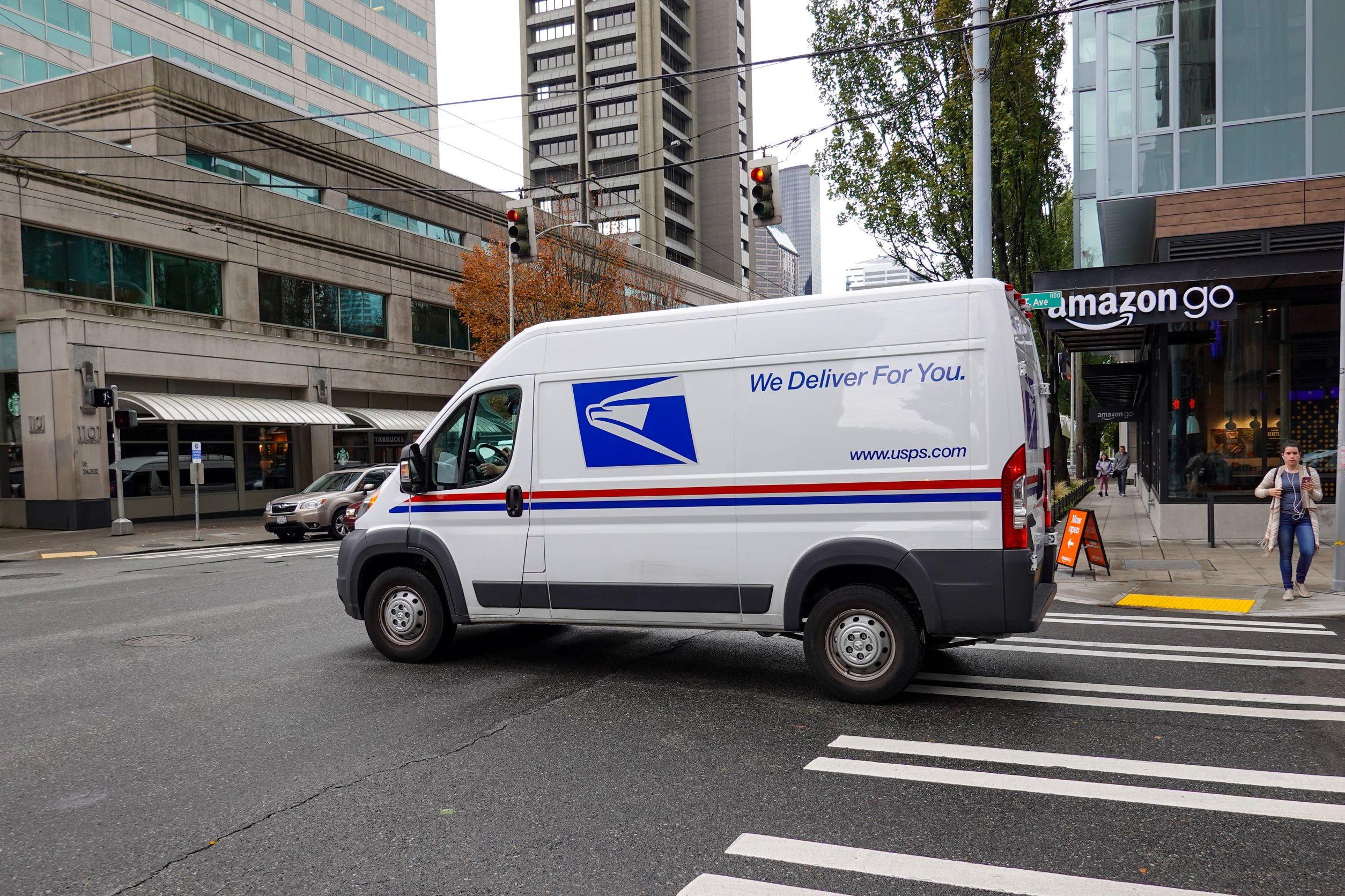 A United States Postal Service Truck making deliveries in an urb