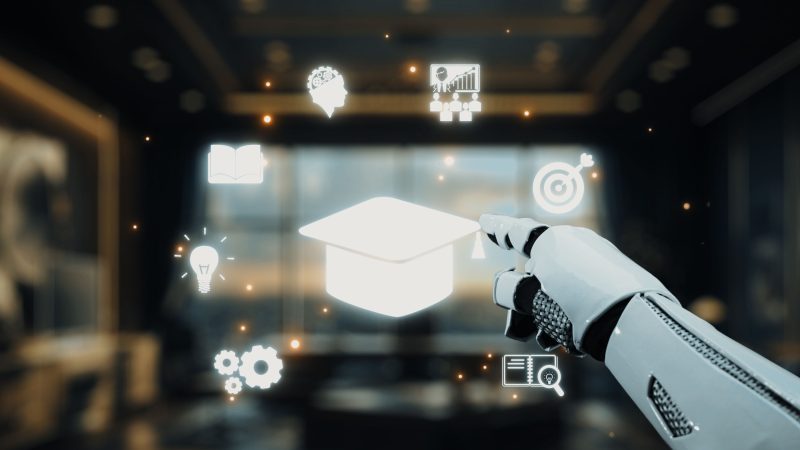 Futuristic Robotic Hand Pointing at Educational Icons in a Modern Office Setting with Blurred Background. Auvana