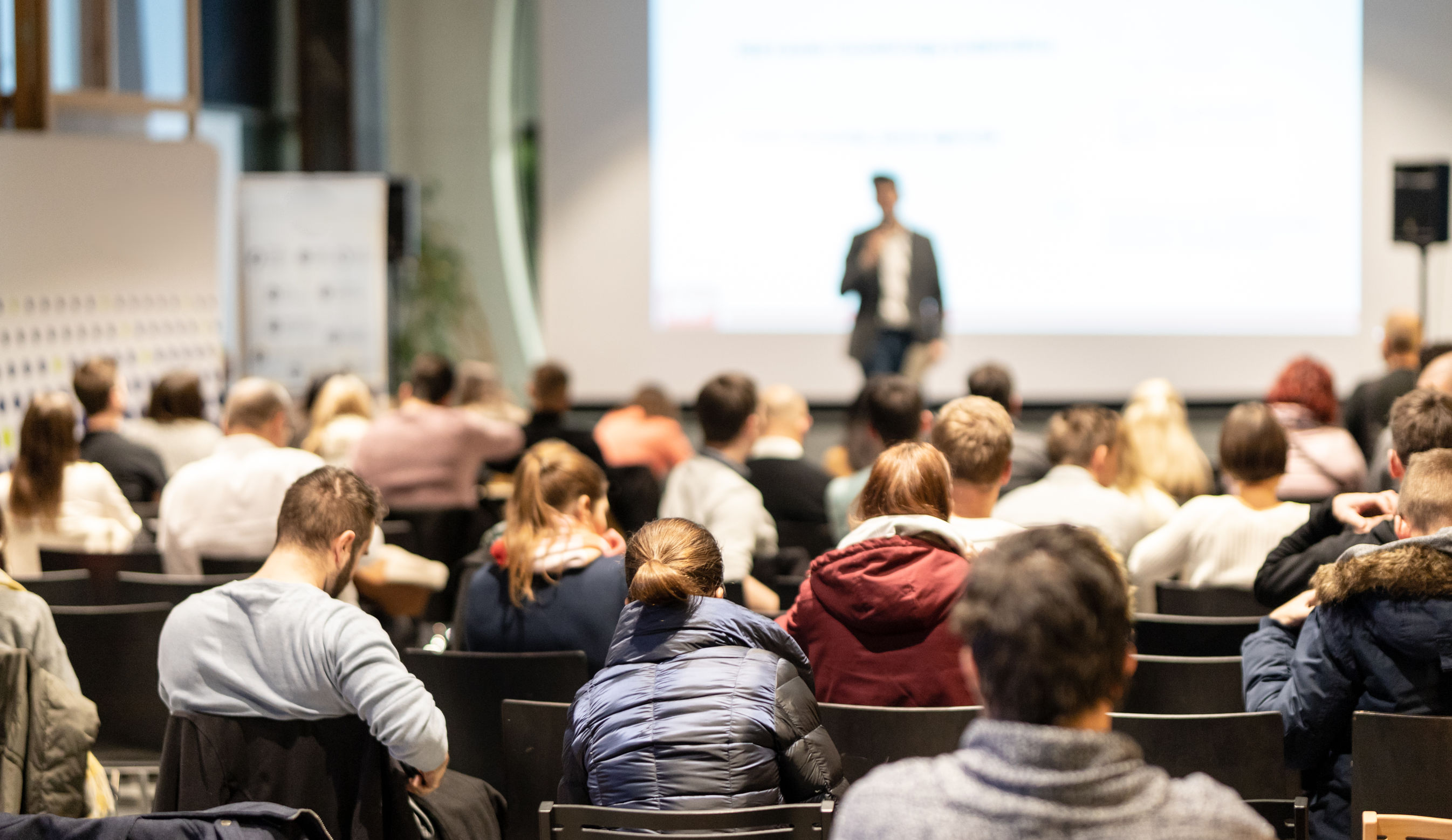 Business speaker giving a talk at business conference event.