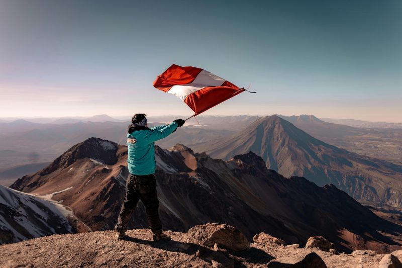 Man Waving a Peruvian Flag in the Andes