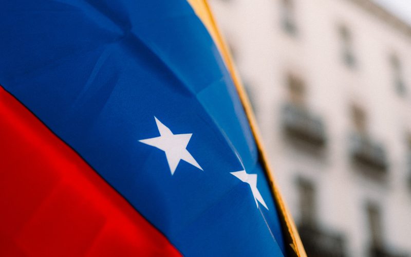 Close-up of the vibrant Venezuelan flag with stars in an urban environment, symbolizing national pride.