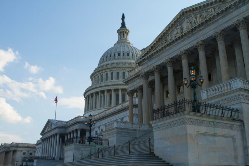 Classic view of the historic US Capitol Building in Washington, DC, with a clear blue sky.