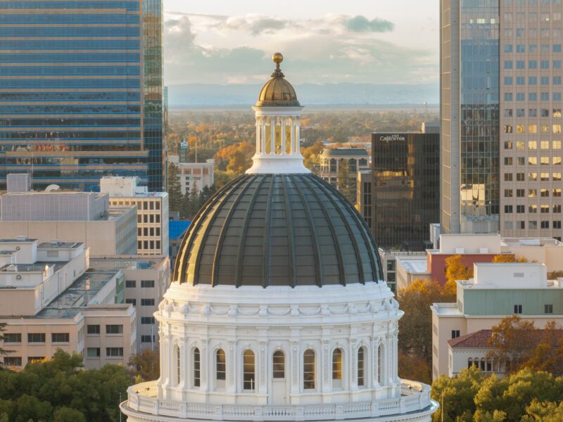Captivating aerial view of the California State Capitol dome surrounded by Sacramento's cityscape.