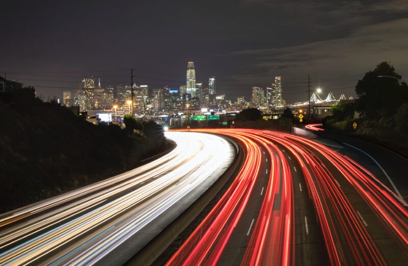 Vibrant long exposure of highway light trails in a bustling city at night.