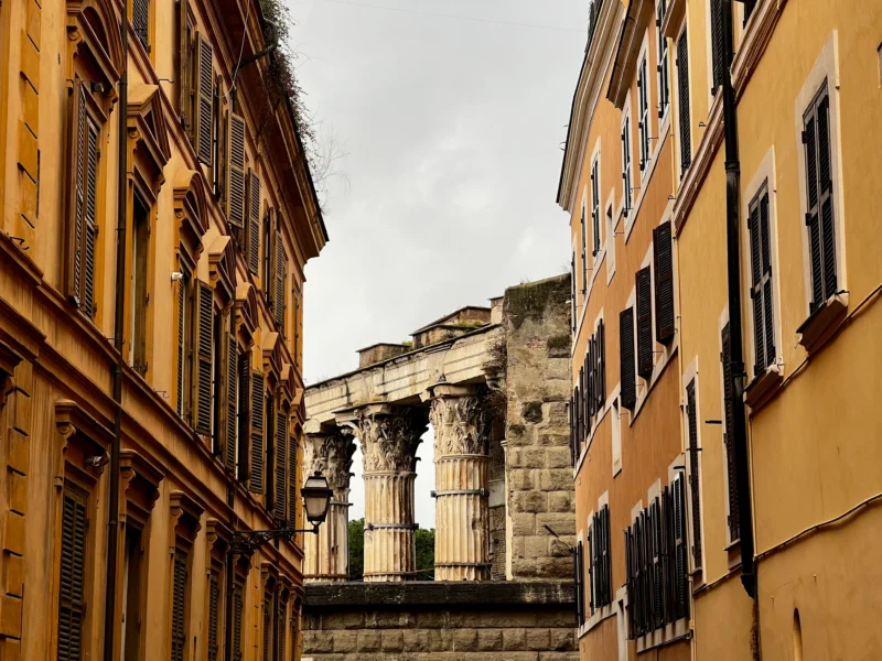 ancient Roman ruins flanked by charming buildings.